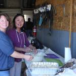 (From left to right) Brandi Blauvelt, daughter of owners Elaine and Dale Griner, and Thurmond&rsquo;s employee Janet George prepare fresh deep-fried halibut for those attending the fourth annual Thurmond&rsquo;s Far West Auto Customer Appreciation Day on Saturday, June 9 in Anchor Point, Alaska. (Photo by Delcenia Cosman)