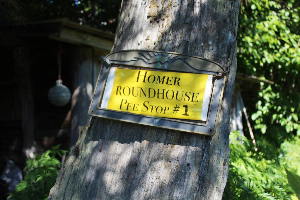 A sign, shown here Monday, July 2, 2018, affixed to a tree outside a rental on Hidden Way in Homer, Alaska, reads Homer Roundhouse Pee Stop #1 The couple who rented the yurt briefly set out from threre on a cycling trek to Argentina on Monday. Their adventure blog is titled The Places I Pee. (Photo by Megan Pacer/Homer News)