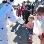 A member of the Homer Animal Friends hands out a dog treat to a young girl during this years Independence Day parade Wednesday, July 4, 2018 in Homer, Alaska. (Photo by Megan Pacer/Homer News)