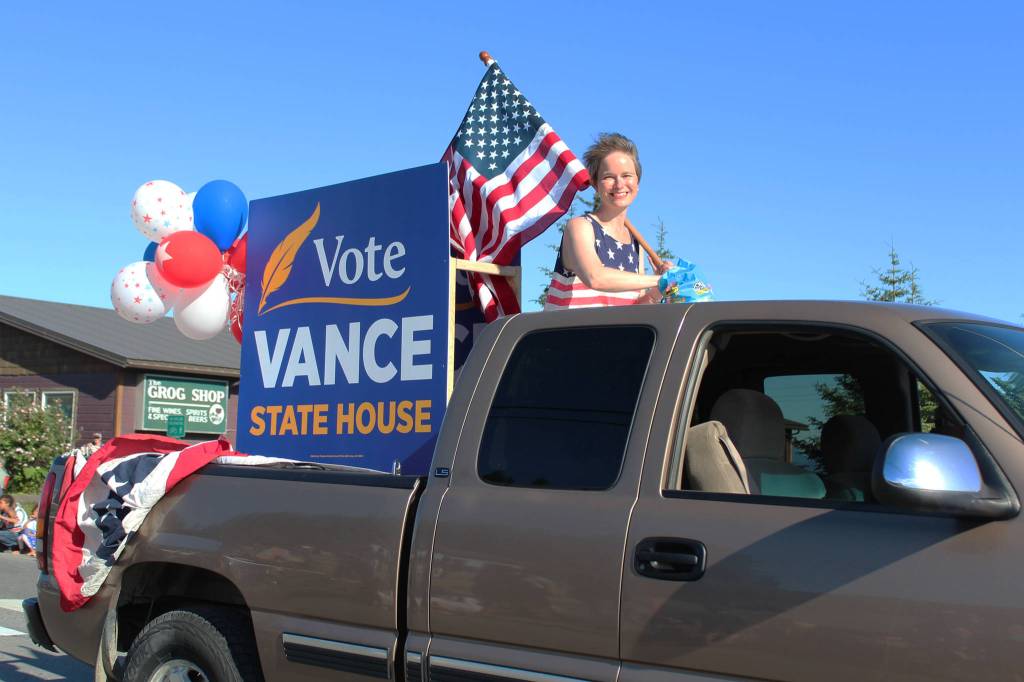Sarah Vance, who is running for a seat in the Alaska House of Representatives, rides in the back of a truck during this years Independence Day parade Wednesday, July 4, 2018 in Homer, Alaska. Several political figures and candidates had floats in this years parade. (Photo by Megan Pacer/Homer News)