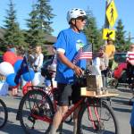 Wayne Adderhold moves along with the Friends of the Homer Library during this years Independence Day parade Wednesday, July 4, 2018 on Pioneer Avenue in Homer, Alaska. The friends handed out books to children as they marched and performed their own book-focused dance. (Photo by Megan Pacer/Homer News)