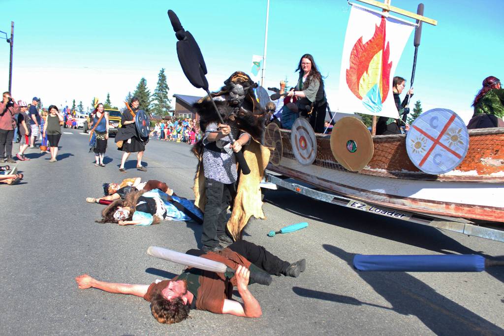Members of the Shire of IceFire Bay live action role playing group stage a battle on and around their float during this years Independence Day parade Wednesday, July 4, 2018 in Homer, Alaska. (Photo by Megan Pacer/Homer News)