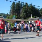 Two men carry a caber  a type of log thrown during Scottish highland games  during the annual Independence Day parade Wednesday, July 4, 2018 on Pioneer Avenue in Homer, Alaska. (Photo by Megan Pacer/Homer News)