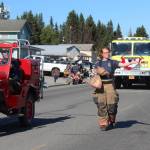A member of the Homer Volunteer Fire Department tosses candy to parade goers during the annual Independence Day parade Wednesday, July 4, 2018 in Homer, Alaska. (Photo by Megan Pacer/Homer News)