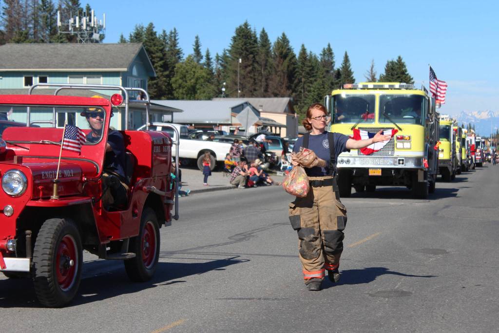 A member of the Homer Volunteer Fire Department tosses candy to parade goers during the annual Independence Day parade Wednesday, July 4, 2018 in Homer, Alaska. (Photo by Megan Pacer/Homer News)