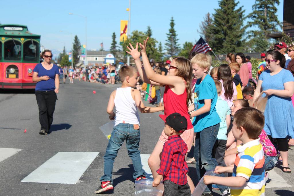 Children scramble for candy tossed from passing floats and parade walkers during this years Independence Day parade Wednesday, July 4, 2018 on Pioneer Avenue in Homer, Alaska. (Photo by Megan Pacer/Homer News)