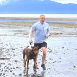 A runner approaches the finish line of the Chariots of Fur 5K with his dog on Saturday, July 14, 2018 near Mariner Park in Homer, Alaska. (Photo by Megan Pacer/Homer News)