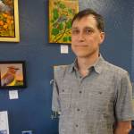 Bird is the word Palmer artist Francois Girard stands by art from his show, Alaska Wings, at the First Friday opening on July 6 at the Art Shop Gallery in Homer, Alaska. Girard creates sculptures he calls Bird Blocks made from prints adhered to wood and varnished. He also displays some of his original paintings. (Photo by Michael Armstrong/Homer News)