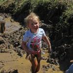 Polly Fraley looks toward her mother and sister, who are sitting on the edge of the mud pit at this years Mud Games, also called the Mud Wallow, held Sunday, July 22, 2018 at Cottonwood Horse Park in Homer, Alaska. (Photo by Megan Pacer/Homer News)