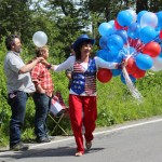 Rainey and Elias Sundheim add some holiday decorations to their bicycles at NOMAR before Homer’s July 4th parade.-Photo by McKibben Jackinsky, Homer News