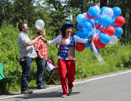 Rainey and Elias Sundheim add some holiday decorations to their bicycles at NOMAR before Homer’s July 4th parade.-Photo by McKibben Jackinsky, Homer News