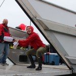 Steve Attleson, owner of the M/V Sanoah, looks on as Nataha Huestis prepares to break a bottle of champagne at the vessel’s christening ceremony in the Homer Harbor on Sunday. The Sanoah is named in memory of Huestis’ daughter.