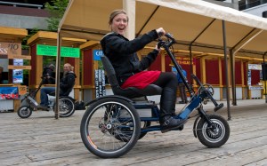 Kellen Priest, right, and Abby Leatherman, both tour brokers for Gastineau Guiding, ride electric-powered tricycles in  downtown Juneau late last month. Bob Janes invented the Access Hybrid, a trike with an assistive electric motor, meant to provide all the fun of a bicycle and all the function of a traditional mobility device. -Photo by Michael Penn, Morris News Service - Alaska