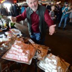 Homer Chamber of Commerce board member Tom Stroozas delights in the homemade marshmallow offerings from Red Bird Kitchen.-Photo by Jim Lavrakas, Far North Photography