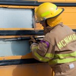 Firefighters from Homer and the Alpine Fire Department work together to open the side of a school bus.-Photo by Heather Ericson