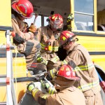Firefighters from Homer and the Alpine Fire Department work together to open the side of a school bus.-Photo by Heather Ericson