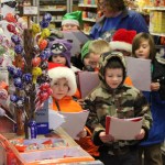 students in Lila Johnson’s second-grade class at Chapman School carol at Anchor River Inn Store-Photos by Michael Armstrong and McKibben Jackinsky, Homer News; and Derotha Ferraro