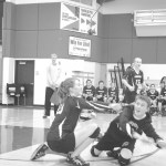 Nikolaevsk senior Serafima Kalugin goes to the ground for a dig with an assist by sophomore Kalenik Molodih. Sophomore Vera Fefelov reacts to support her team.-Photo by Nicetas Lasiter