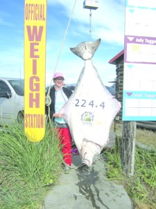Linda Scott of Bloomington, Minn., poses with the 224.4-pound halibut she caught while fishing with DeepStrike Sportsfishing aboard the Grand Aleutian captained by David Bayes. She is the current leader in the Homer Jackpot Halibut Derby.