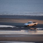 A person drives a truck through tidepools at Bishop’s Beach.-Photo by Michael Armstrong, Homer News