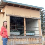 Kyra Wagner stands by her beehouse at her house off East End Road. The wire protects her hives from being destroyed by bears.-Photo by Michael Armstrong, Homer News