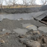 Filter fabric hanges below a section of Kachemak Drive that washed out on Sunday,-Photo by Michael Armstrong, Homer News