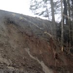Mud slides down a bluff below where a section of Kachemak Drive washed out on Sunday morning.-Photo by Michael Armstrong, Homer News