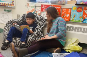 17-year-old Claire Swanson of Christian Community Church’s Ignite Youth group reads with a boy from Ouzinkie during a spring break trip to the village, located on Spruce Island. -Photo provided