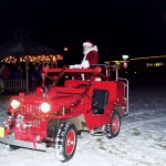 In 2004, Santa Claus arrives in Engine No. 1, a vintage Willys Jeep,  at WKFL Park for the lighting of the community Christmas tree there.-Photo by Michael Armstrong, Homer News