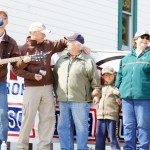 Nashville singer Lucas Hoge, left, performs during the American 300’s presentation of the Wrangler National Patriot Memorial Day Tour in the NOMAR parking lot on Sunday. Rob Powers, second from left, of American 300 honors Ben Mitchell, standing with his grandson Willem, wife Kate and Bill Sheldon of American Legion Post 16.  -Photo provided