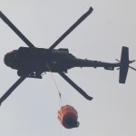 A Black Hawk helicopter prepares to drop a bucket of water on a hot spot of the Funny River Horse Trail wildfire that encroached into the Funny River community, Sunday May 25, 2014, in Soldotna, Alaska. The wildfire has burned more than 156,041 acres of Kenai National Wildlife Refuge land and threatens the communities of Kasilof, Funny River, Soldotna, Sterling and Bear Creek.