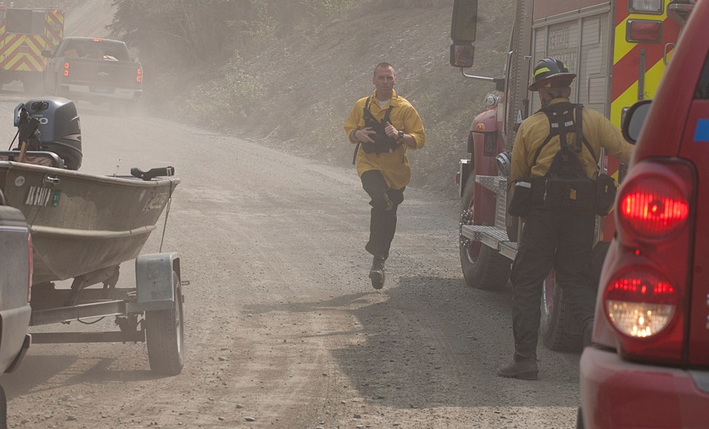 Spectators motored close to shore on the Kenai River as firefighters from Central Emergency Services fought to keep a portion of the 156,000 acre Funny River Horse Trail wildfire from burning into a neighorhood in off of Funny River Road Monday May 26, 2014 in Soldotna, Alaska. The wildfire ignited a trailer across the river in the Kenai Keys neighborhood — but firefighters extinguished the blaze.-Photo by Rashah McChesney/Morris News Service-Peninsula Clarion