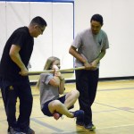 Native Youth Olympics athletes Sam Strange, left, and Thomas, right, carry Daisy Kettle in a demonstration of the wrist carry. At right, Rhythm Beckett-Cook tries the one-foot high kick.-Photos by Michael Armstrong