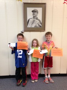 Paul Banks Elementary School students Einar Pederson, Katrina Marshall and Nathaniel Theisan, pose beneath a photo of the school’s namesake. The three were recognized for their perfect school attendance during the 2013-2014 school year.