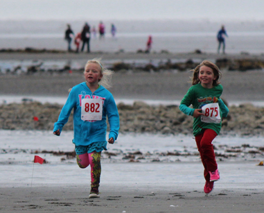 Channing Lowney, 7, and Nuala Stenson, 6, dash to fourth and fifth place, respectively in the one-mile course.-Photo by McKibben Jackinsky, Homer News