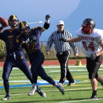 Mariner Josh Fisk, 32, secures space for teammate Shelton Hutt, 7, to throw a pass.-Photo by McKibben Jackinsky, Homer News