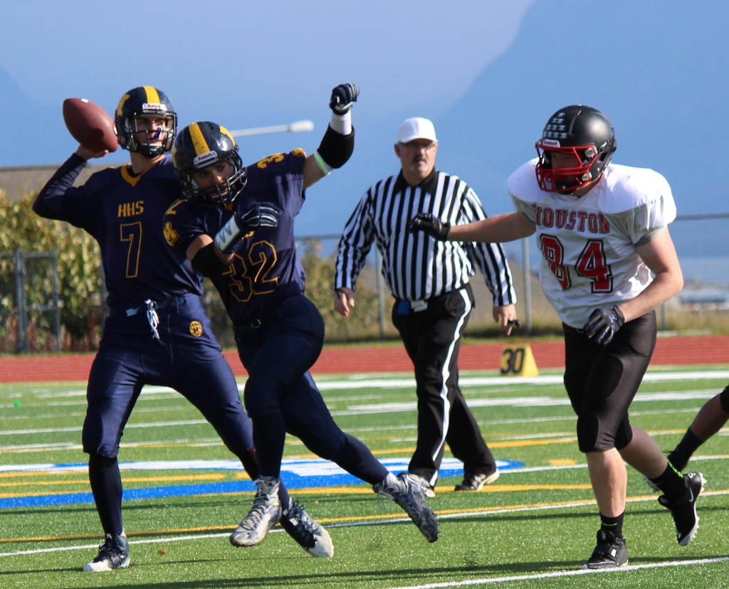 Mariner Josh Fisk, 32, secures space for teammate Shelton Hutt, 7, to throw a pass.-Photo by McKibben Jackinsky, Homer News
