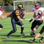 Mariner Connor Seay struggles against the tight clutches of the Houston Hawks defense.-Photo by McKibben Jackinsky, Homer News