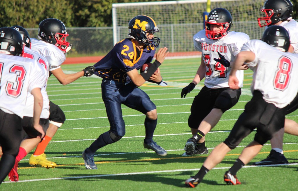 Mariner Connor Seay struggles against the tight clutches of the Houston Hawks defense.-Photo by McKibben Jackinsky, Homer News