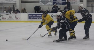 Mariner forwards Owen Delehanty, 10, and Clem Tillion, 17, fend off SoHi players in a fight to control the puck.-Photo by McKibben Jackinsky, Homer News