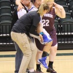 Nadejda Gordeev, 22, of the Nikolaevsk Warriors, helps an injured Newhalen Malamute player off the floor.-Photo by McKibben Jackinsky, Homer News