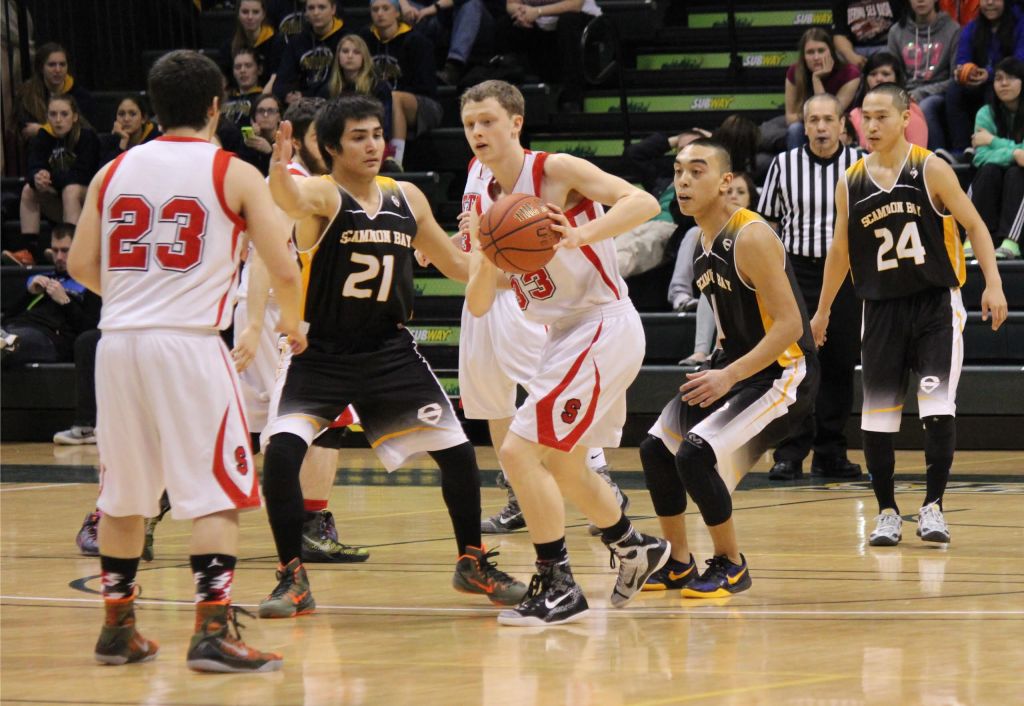 Seldovia's Dylan Waterbury, 23, and Aidan Philpot, 33, keep the ball away from Scammon Bay during State championship play in Anchorage, March 18.-Photo by McKibben Jackinsky, Homer News