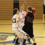 Mariner JVs Zach Raham, No. 23, and Justin Elison, No. 5, block a pass by Sea Otter Seth O’Leary, No. 34.-Photo by McKibben Jackinsky, Homer News
