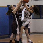 Ninilchik’s Olive Delgado, right, fights for control of the ball with Nikolaevsk’s Kilina Klaich, left, and Serafima Kalugin, center.-Photo by McKibben Jackinsky, Homer News