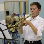 KSC swimmer Ethan Benedetti begins Saturday’s competition by playing The  Star Spangled Banner.-Photo by McKibben Jackinsky, Homer News