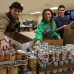 Homer High School students Evan Boyer, Sarah Wolf and Zane Boyer help with the Kachemak Bay Lions Thanksgiving Basket Program at the Homer United Methodist Church on Saturday morning.-Photo by McKibben Jackinsky, Homer News
