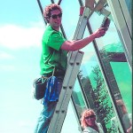raig Thomas, left, washes windows at the Homer Public Library with Clear View owner Bev Vosburgh, right.-Photo provided