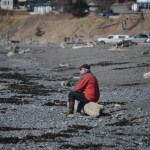 A man sits on a log at Bishop’s Beach on April 3. Nothing in the beach policy recommendations would prohibit this.-Photo by Michael Armstrong, Homer News