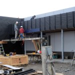 Workers last Thursday install siding at the entrance to the new Harbormaster’s Office.-Photo by Michael Armstrong, Homer News