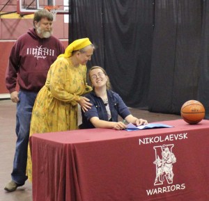 Nianiella Dorvall, right, is congratulated Monday by her parents after signing a letter of intent to play basketball for Skagit Valley College. -Photo by McKIbben Jackinsky, Homer News
